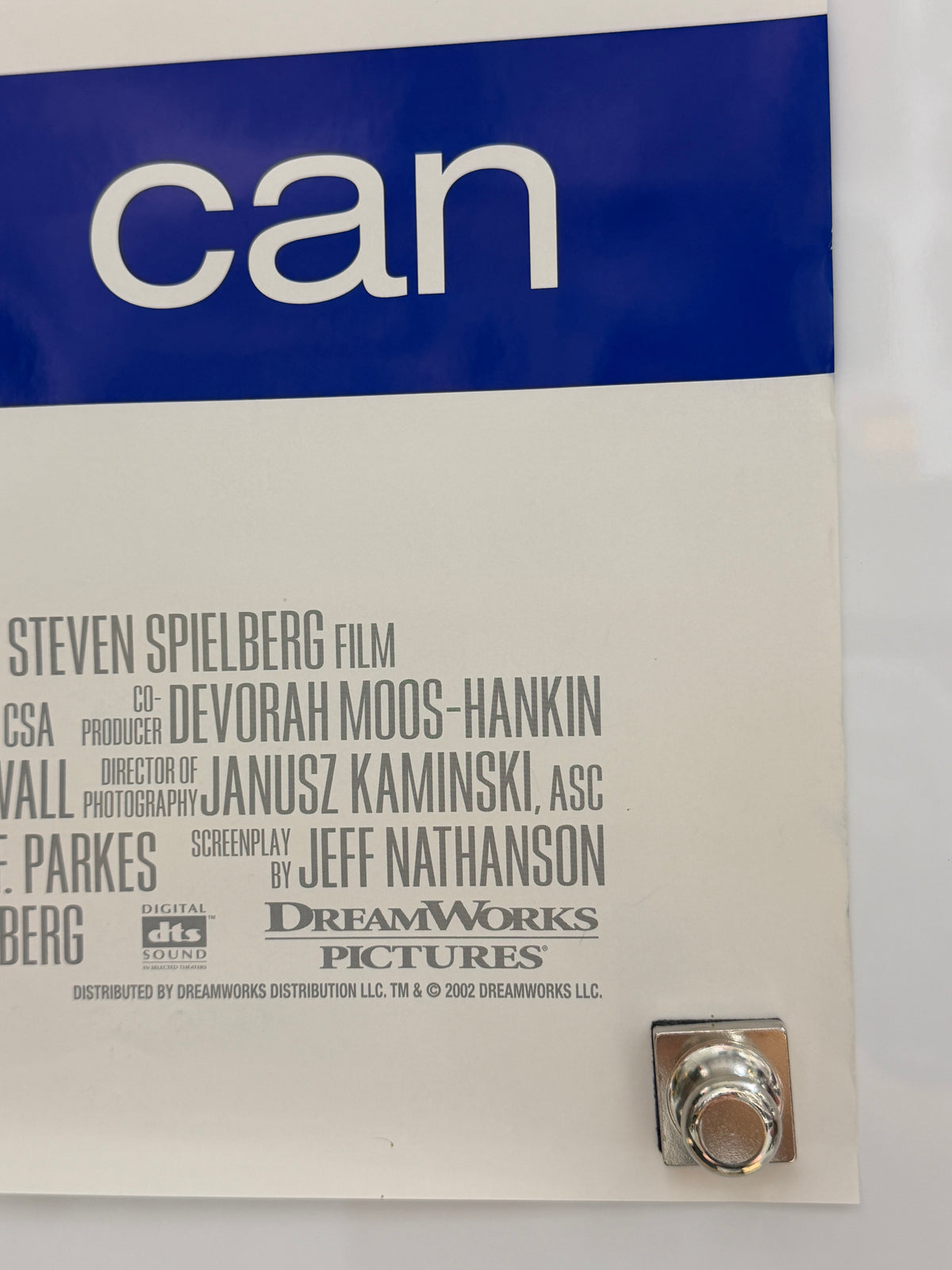 A close-up of a printed movie poster or cover for the film 'can', showing a blue vertical band with the word 'can' in large white letters on the left, a white background with film credits in black text, and a small metallic logo near the top right.