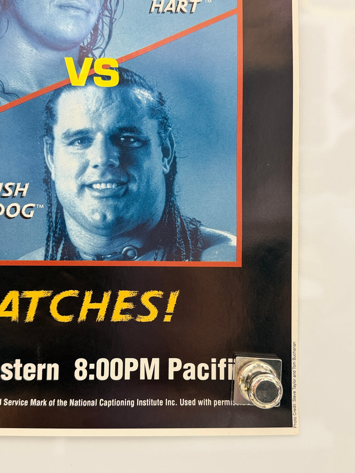 A close-up of a wrestling event poster featuring a blue-toned portrait of a man with the text 'VS' and 'WATCHES!' in yellow, plus partial venue and time text at the bottom.